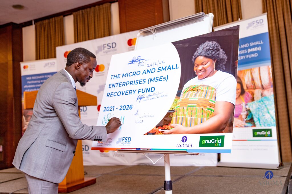 ASIGMA MD, signs the launch card at the fund's launch ceremony.